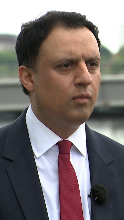 Anas Sarwar - man wearing dark suit and red tie, standing on the banks of the River Clyde