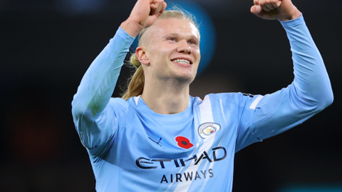 Erling Haaland celebrates in a Manchester City shirt