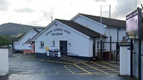 St Canice's GAC Dungiven - a white building with a ramp outside and the name above the entrace in Irish