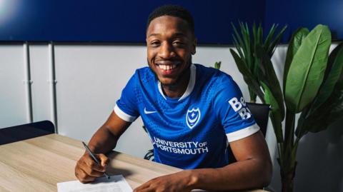 Ebou Adams poses for a photo after signing his contract 
