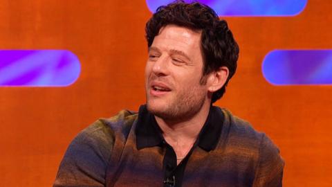 James Norton wearing a brown jumper in the Graham Norton studio.