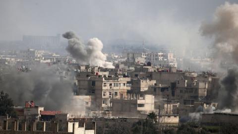 A picture taken on February 20, 2018 shows smoke plumes rising following a reported regime air strike in the rebel-held town of Hamouria, in the besieged Eastern Ghouta region on the outskirts of the capital Damascus.