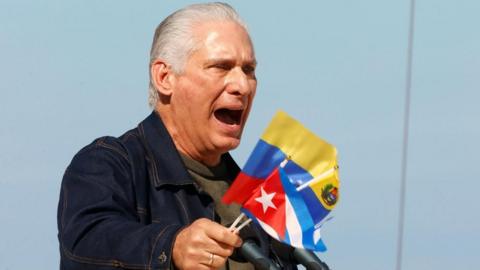 Cuban President Miguel Díaz-Canel holds Cuban and Venezuelan flags as he speaks at a rally in Havana in support of Venezuela. Photo: 3 January 2026