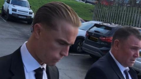 Two men in suits arrive at court