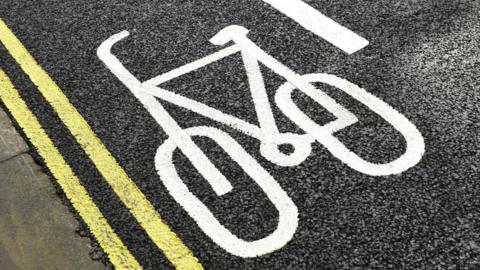 bike lane with white bike painted and double yellow lines next to pavement