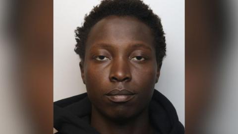 Rooney Gardi's custody picture. He has short dark curly hair and is wearing a black hoodie. 