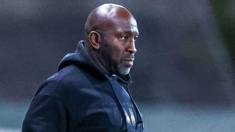 Port Vale manager Darren Moore looks on from the touchline during a game