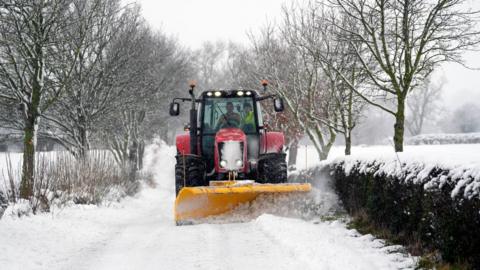 A tractor clearing snow from a road in North Yorkshire