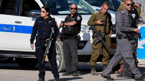 Israeli security personnel standing in front of a vehicle (file photo)