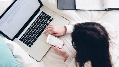 Girl on bed looking at a computer