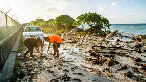 A photo taken in 2021 shows high-tide flooding and debris covering the road to the airport in the Marshall Islands capital Majuro. Storms and tidal surges caused widespread flooding, with rising seas blamed for the inundation in the climate-change affected region. 