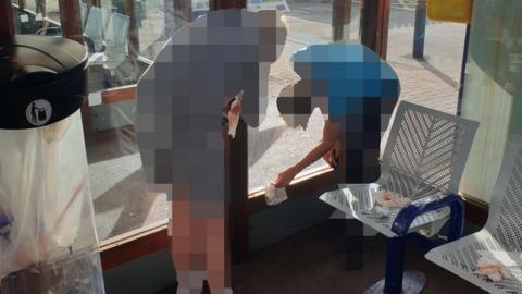 Two heavily pixellated boys wipe around a window