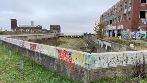 Derelict buildings at the former dock with broken windows and covered in graffiti 