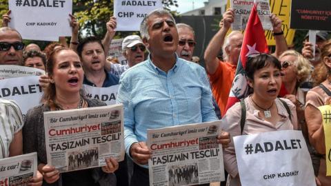 People hold placards read "Justice" as they shout slogans on June 15, 2017 in Istanbul during a demonstration to protest the jailing of one of its MPs.