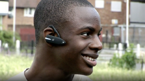 Image of Mr Akerele wearing a Bluetooth headset and smiling