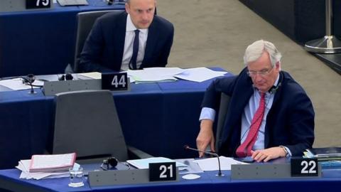 Michel Barnier using his phone during a debate in the European Parliament