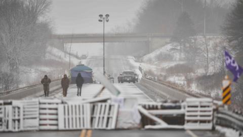 First Nations protestors walk on a bridge past their barricade on Highway 6 near Caledonia, Ontario which the protestors set up in support of the Wet"suwet"en hereditary chiefs and the Tyendinaga Mohawks on February 26, 2020
