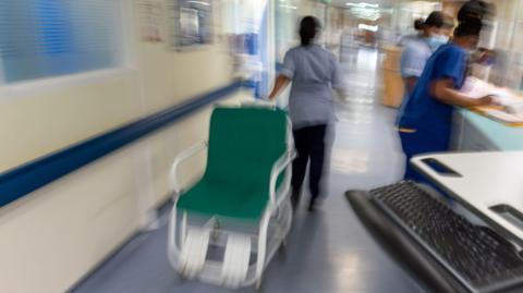 NHS ward staff hurry to care for patients.
