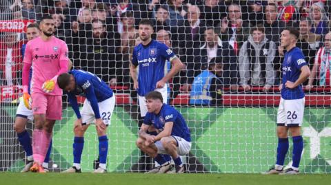 Ipswich players stand dejected after conceding a goal