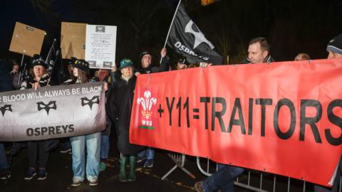 Protestwyr yn dal baner