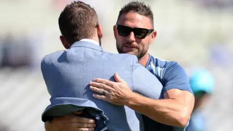 Brendon McCullum is hugged by Eoin Morgan