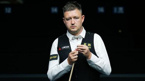 Kyren Wilson chalking his cue