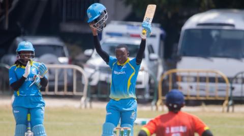 Fanny Utagushimaninde raises her bat to acknowledge a century
