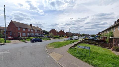 An image of a residential street called Henderson Drive in Dartford, It appears quiet, with just one car and no people present.