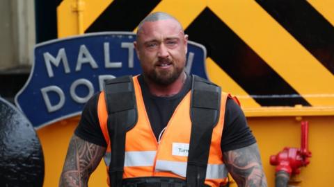 Stuart Lambert wearing a hi-viz jacket in front of a diesel locomotive