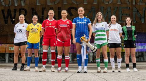 Players from all eight Adran Premier teams pose with trophy outside the Welsh Millennium Centre