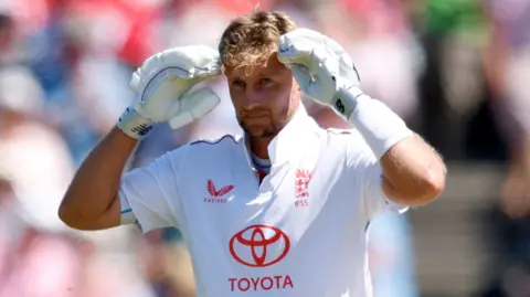 England batter Joe Root puts his gloves to his head in celebration after reaching a century