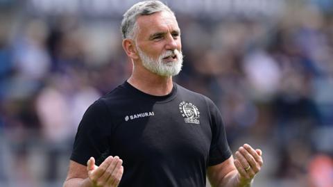 Ricky Pellow gestures with both hands
