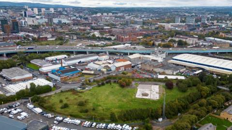 An aerial view of part of Glasgow, including a large, empty bit of grassy land