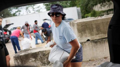 Valerie Jackson loads up an SUV with sandbags ahead of the arrival of Hurricane Milton