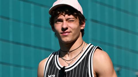 Kimi Antonelli winking and wearing a vest at the Miami Grand Prix