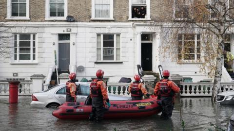 Fire crews with boat rescuing people