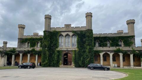 Lincoln Crown Court a two-storey Victorian Gothic building with stone pillars, crenellated roof and six towers with ivy growing up its walls