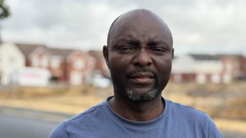 A close up of man in his late forties wearing a dark blue t-shirt