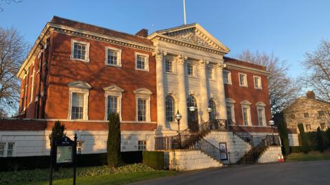 The two-storey, red brick Warrington Town Hall on a sunny day. 
