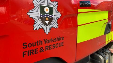 Stock image showing a close-up of a fire engine with the South Yorkshire Fire & Rescue logo