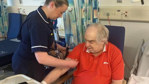 Stephen Roberts, a patient at the hospital, has his blood pressure taken by a nurse on the ward