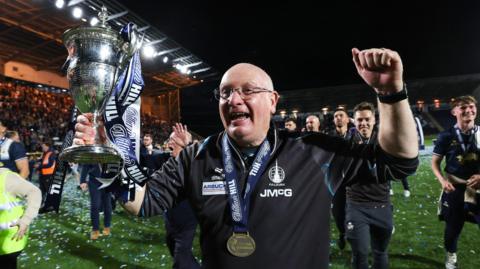 John McGlynn celebrates with the Scottish Championship trophy
