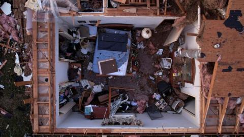 A missing roof exposes a home's bedroom in the aftermath of a tornado in Wynne, Arkansas