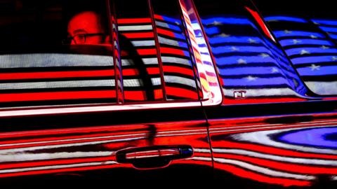 The US flag is reflected in a taxi window during the 100th New York Veterans Day Parade.