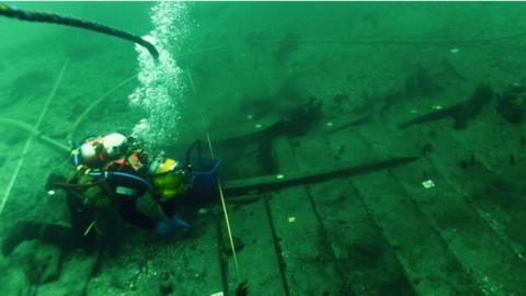 A diver underwater taking a closer look at the ship.