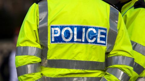 Back view of a police officer in reflective jacket - stock photo