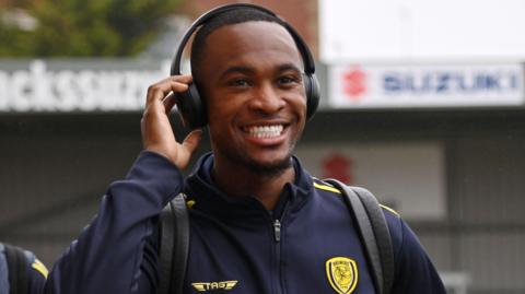 Rekeem Harper with headphones on, smiling, ahead of a Burton Albion game