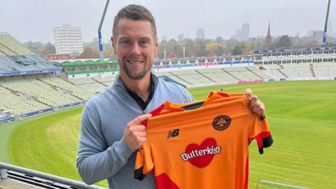 New women's head coach Alistair Maiden holds up the Birmingham Phoenix jersey