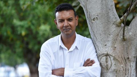 Arup Biswas, the founder of Klaxon AI, standing by a tree