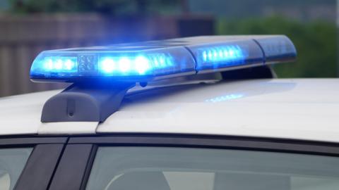 A stock image of flashing blue lights on top of a police vehicle